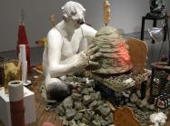 Nicole Eisenman, Maker's Muck, 2022. Coney Island Boardwalk (Brazilian Ipe), plaster, bronze, silicone, unfired clay, fired clay, expanding foam, burlap, wire, raw wool, sneakers, magic smooth, magic sculpt, resin, bamboo skewers, tin foil, plaster bandages, plywood, bass wood, Aqua-Resin, fiberglass, seashell, styrofoam, oil paint, wax, carpet fringe, cardboard, cement, steel pipe, steel rod, aluminum paint tubes, vinyl stickers, granite, telescopic extension pole, sand, fabric, crocheted rug, marbles, min