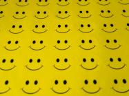 a sheet of yellow fabric with rows and rows of smiley faces